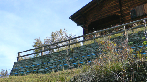 Ich habe sogar eine lange hohe Steinmauer bauen müssen, um das Chalet zu stützen.