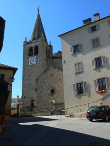 Ich mache mich von Les Vernys aus auf in ein Dorf, das sich auf der anderen Seite der Rhone abzeichnet.Lens kommt näher wie eine Straße im Himmel. Fast pralle ich gegen die Kirche, die wie ein Schiff dasteht.